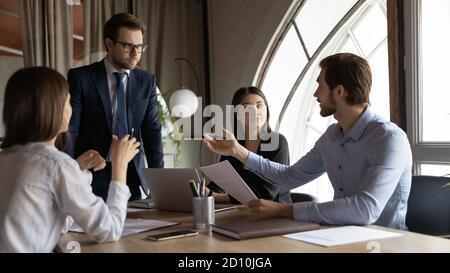 Focused young team leader holding brainstorming meeting in office. Stock Photo