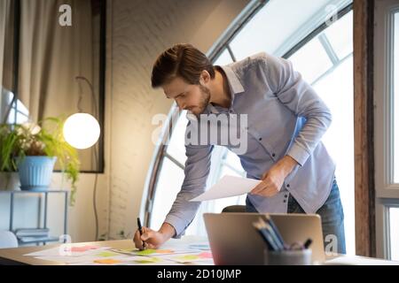 Serious skilled male employee involved in workflow management activity. Stock Photo
