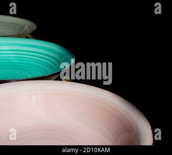 Pastel colored Soup plates in a diagonal line. High contrast and deep shadows Stock Photo
