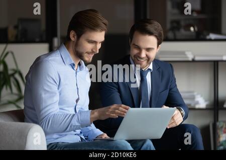 Two smiling businessmen discussing good project results. Stock Photo