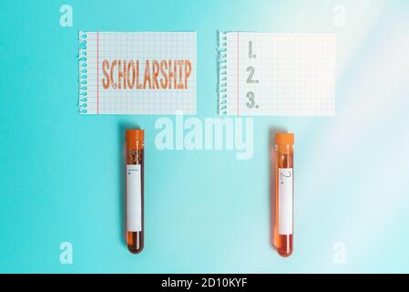 Writing note showing Scholarship. Business concept for grant or payment made to support a student s is education Blood sample vial medical accessories Stock Photo