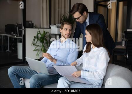 Focused young diverse business people discussing growth strategy. Stock Photo