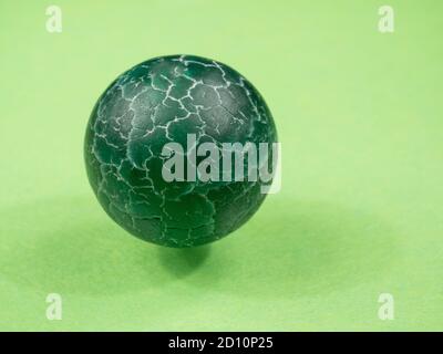 Natural stone bead close-up. Green mineral. Green background. Macro. Stock Photo