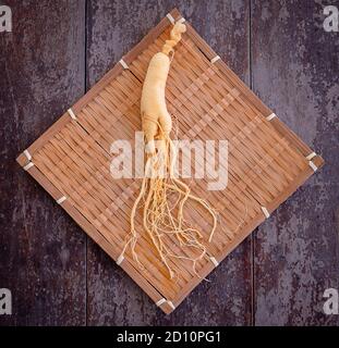 Fresh ginseng on bamboo weave with the wood background Stock Photo