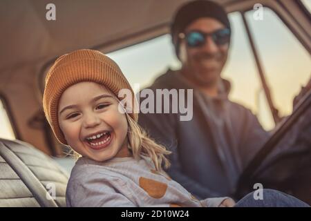 Cheerful Family Having Fun Together in the Car. Enjoying Road Trip. Father with Pleasure Teaching his Little Son to Driving Auto. Happy Fatherhood. Stock Photo