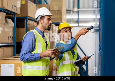 Middle east turkish white warehouse manager working about inventory with Islam asian warehouse worker in distribution center. For business warehouse i Stock Photo