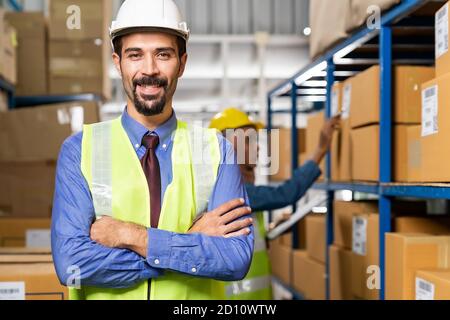 Portrait of Middle east Turkish White caucasian warehouse manager crossed arm with his worker working in background in warehouse distribution center e Stock Photo