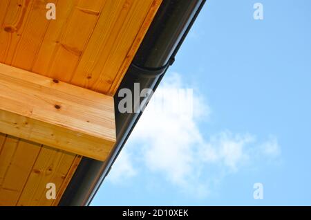 Low angle view of wood paneled roof with drain on a blue sky background. Stock Photo
