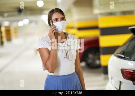 Adult woman using cellphone in underground parking lot Stock Photo