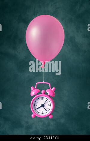 Alarm clock flying on balloon Stock Photo