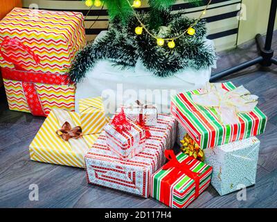 Christmas gifts in boxes with patterned wrapping rewound ribbons lie on the floor Stock Photo