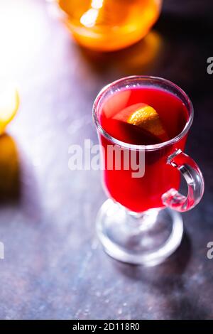 Christmas mulled wine on a dark background. Glass of mulled wine glows in the backlight. Traditional hot drink at Christmas time Stock Photo