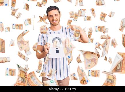 Handsome young man with bear holding question mark pointing finger to one self smiling happy and proud Stock Photo