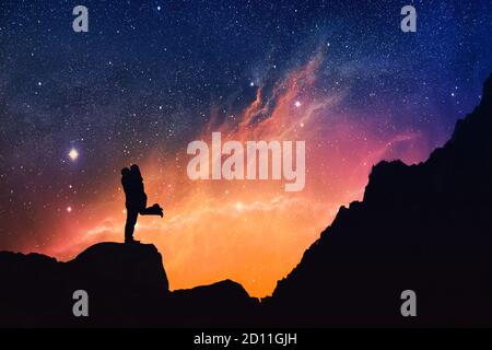 Silhouette of a Couple kissing on a starry night, Falling in Love at Valentine's Day, dating, love romance concept. Dramatic scenery. Stock Photo