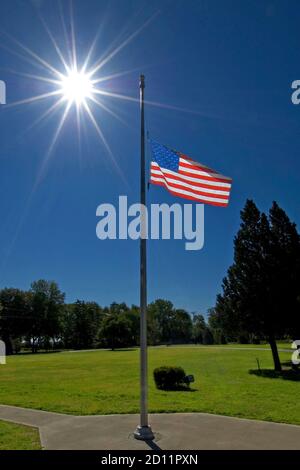 United States American flag flying flies at half mast staff Stock Photo