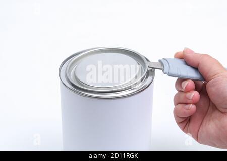 An open can and hand holding a can opener Stock Photo - Alamy