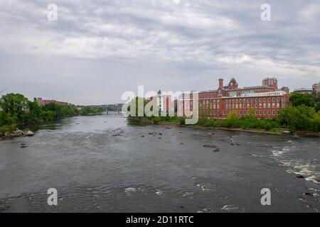 Historic Amoskeag Mill buildings at the bank of Merrimack River in downtown Manchester, New Hampshire NH, USA. Stock Photo