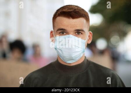 Guy in face mask over group of demonstrators Stock Photo