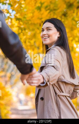 Emotional young woman pulling her man hand, walking by forest Stock Photo