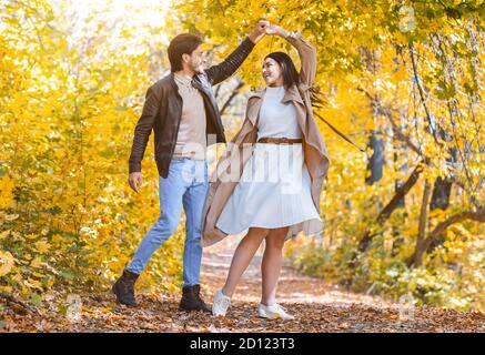 Romantic joyful couple dancing in the middle of forest Stock Photo