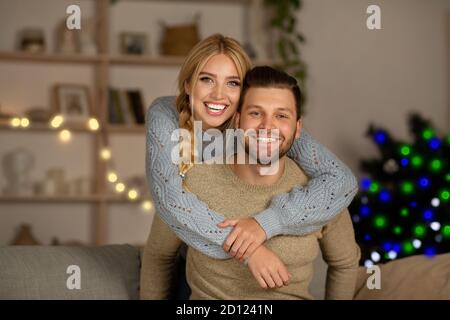 Loving couple cuddling at home during Christmas eve Stock Photo