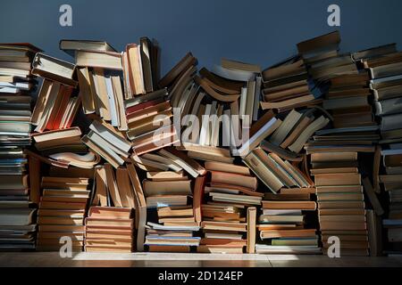 Wall of books piled up in the attic Stock Photo