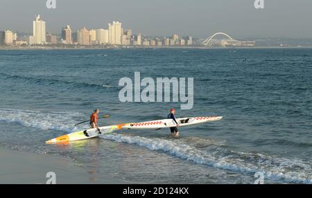 Man and woman canoeing in bay of Durban, KwaZulu-Natal, South Africa, landscape, people, city, skyline, beach, beachfront, waterfront, activity, sport Stock Photo