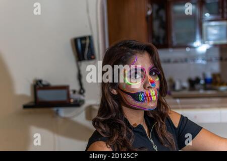 woman putting makeup on another woman for a party of the day of the dead Stock Photo