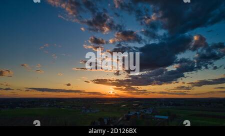Aerial view of a Sunset over barns, silos and farmlands during the ...