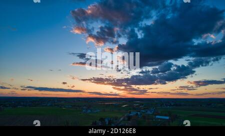 Aerial view of a Sunset over barns, silos and farmlands during the ...