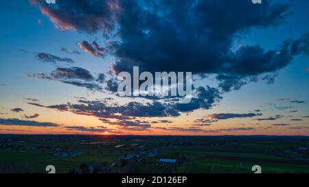 Aerial view of a Sunset over barns, silos and farmlands during the ...