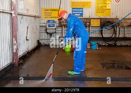 Umea, Norrland Sweden - June 25, 2020: man uses high pressure washer to remove oil residues Stock Photo