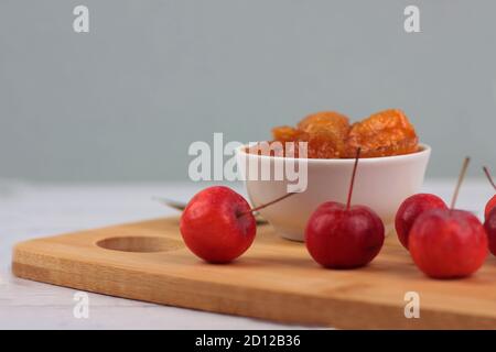 bowl of apple jam and red apples on cutting board against gray background. Image contains copy space Stock Photo