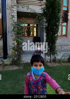Kids play wearing mask after the coronavirus lockdown in asian countries. Stock Photo