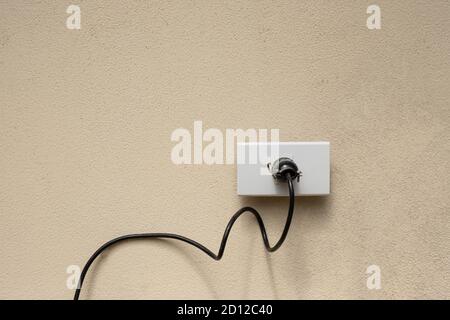 Electric wire plug Receptacle on the concrete wall background Stock Photo