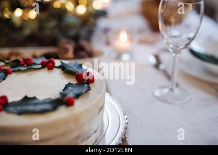 A close-up of cake on table set for dinner meal at Christmas time. Stock Photo