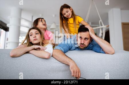Tired mother and father feels annoyed exhausted while noisy little kids at home Stock Photo