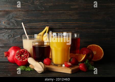 Glasses and jars with different juices on wooden background Stock Photo