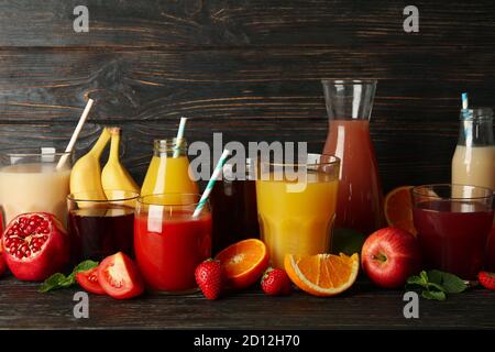 Glasses and jars with different juices on wooden background Stock Photo