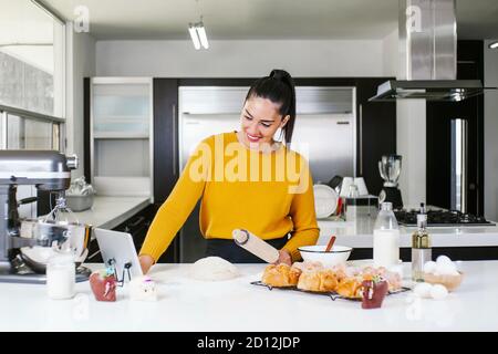 Mexican woman baking Pan de Muerto traditional bread from Mexico in Halloween Stock Photo