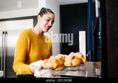 Mexican woman baking bread called pan de muerto traditional from Mexico in Halloween Stock Photo