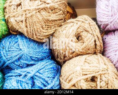 Skeins of blue light brown and lilac woolen yarn. Photo close-up in full screen Stock Photo