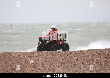 Brighton, UK. 04 October 2020 A Life Guard patrols Brighton Beach on a Quad Bike as High Seas and strong winds hit the South Coast of England  Credit: James Boardman / Alamy Live News Stock Photo