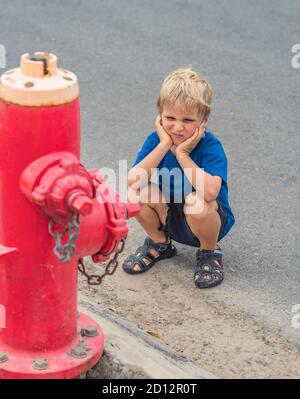 Study everyday knowledge skills. Blond freckled face 5 year boy facial expression blue COVID face mask think about fireman fighters engine looking on Stock Photo