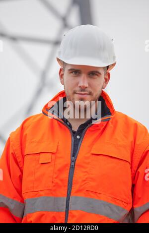 Young confident engineer or architect looking at camera on a construction site - selective focus Stock Photo