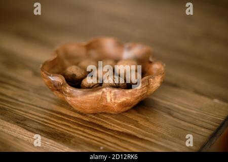 Wooden bowl of unleeled walnuts on the table (photo with shallow depth of field) Stock Photo