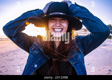 Young bohemian woman portrait on a walk at beach sunset. Horizontal view. Medium shot. Stock Photo