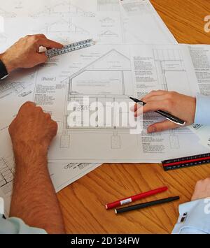 Uk construction industry at work - site meeting looking at plans Stock Photo