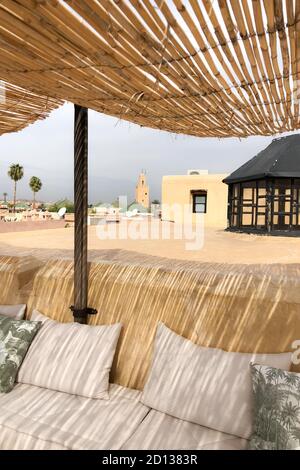 Cafe lounge terrace with sofa, pillows and straw wooden roof. Downtown in medina Marrakesh. Amazing day sunlight, traditional colors of Morocco. Stock Photo
