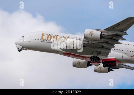Emirates Airbus A380 jet airliner plane A6-EUV taking off in cloudy weather from London Heathrow Airport, UK. Front end tucking up undercarriage